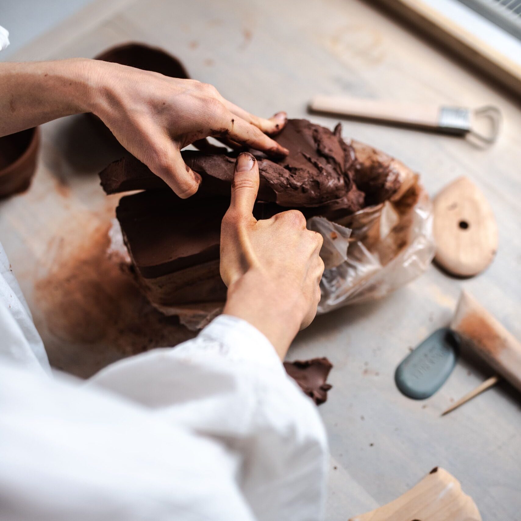 Ręce kobiety dzielące glinę ceramiczną