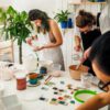 Ludzie szkliwią kolorowymi szkliwami naczynia ceramiczne