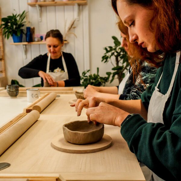 Kobieta lepi miseczkę z gliny ceramicznej